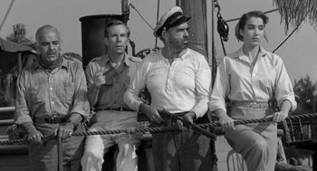Movie still from “Creature from the Black Lagoon” (1954), directed by Jack Arnold – A black and white photo of a group of men on a boat; Medium shot, Low angle