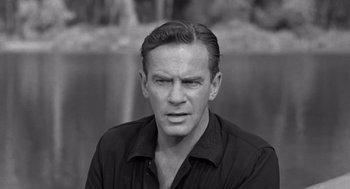 Movie still from “Creature from the Black Lagoon” (1954), directed by Jack Arnold – Black and white photograph of a man in a black shirt; Close Up shot, Over the shoulder angle