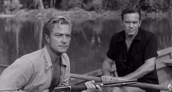 Movie still from “Creature from the Black Lagoon” (1954), directed by Jack Arnold – Two men are sitting in a boat on the water; Medium shot, Over the shoulder angle