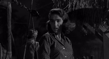 Movie still from “Creature from the Black Lagoon” (1954), directed by Jack Arnold – A black and white photo of a woman in a polka dot shirt; Medium shot, Low angle