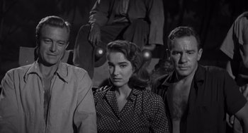 Movie still from “Creature from the Black Lagoon” (1954), directed by Jack Arnold – A black and white photo of a man and a woman and another man; Medium shot, Low angle