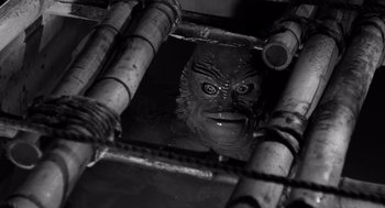 Movie still from “Creature from the Black Lagoon” (1954), directed by Jack Arnold – A creature from the black lagoon mask in the water; Close Up shot, High angle