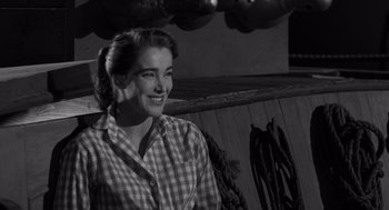 Movie still from “Creature from the Black Lagoon” (1954), directed by Jack Arnold – A woman in a plaid shirt smiling for the camera; Close Up shot, High angle
