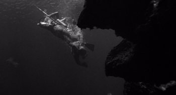 Movie still from “Creature from the Black Lagoon” (1954), directed by Jack Arnold – A person swimming in a body of water; Wide shot, Overhead angle