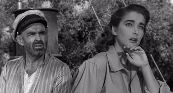 Movie still from “Creature from the Black Lagoon” (1954), directed by Jack Arnold – A man and a woman standing next to each other in front of trees; Close Up shot, Low angle