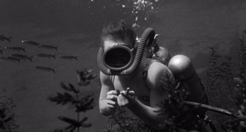 Movie still from “Creature from the Black Lagoon” (1954), directed by Jack Arnold – A man in a scuba mask is in the water; Medium shot, High angle