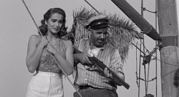 Movie still from “Creature from the Black Lagoon” (1954), directed by Jack Arnold – An old photo of a man and a woman with a gun; Medium shot, Low angle