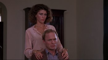 Movie still from “Creepshow” (1982), directed by George A. Romero – A man and a woman are sitting on a chair; Medium shot, Low angle