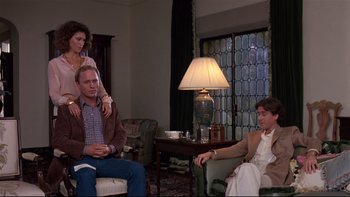 Movie still from “Creepshow” (1982), directed by George A. Romero – A man and a woman sitting in a living room next to a woman; Medium shot, Over the shoulder angle