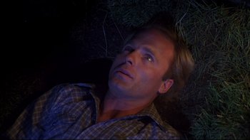 Movie still from “Creepshow” (1982), directed by George A. Romero – A man laying in the grass at night looking up; Close Up shot, Overhead angle