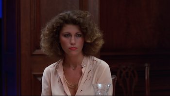 Movie still from “Creepshow” (1982), directed by George A. Romero – A woman sitting at a table with a glass of wine; Close Up shot, Low angle