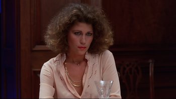 Movie still from “Creepshow” (1982), directed by George A. Romero – A woman sitting in front of a glass of water; Close Up shot, Low angle