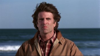 Movie still from “Creepshow” (1982), directed by George A. Romero – A person wearing a jacket near a body of water; Close Up shot, Low angle