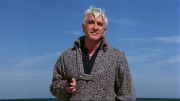 Movie still from “Creepshow” (1982), directed by George A. Romero – An older man holding a cell phone in his hand; Medium shot, Low angle