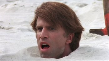 Movie still from “Creepshow” (1982), directed by George A. Romero – A person in the sand; Close Up shot, High angle