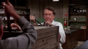 Movie still from “Creepshow” (1982), directed by George A. Romero – A man holding a pair of scissors in his hand; Medium shot, Over the shoulder angle