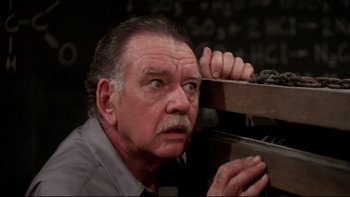 Movie still from “Creepshow” (1982), directed by George A. Romero – An older man with a mustache is leaning against a wall; Close Up shot, High angle