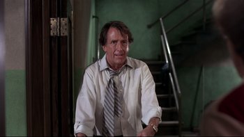 Movie still from “Creepshow” (1982), directed by George A. Romero – A man in a white shirt and a gray neck tie; Medium shot, Low angle