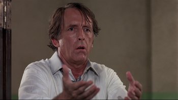 Movie still from “Creepshow” (1982), directed by George A. Romero – A person sitting in front of a microphone; Close Up shot, Low angle