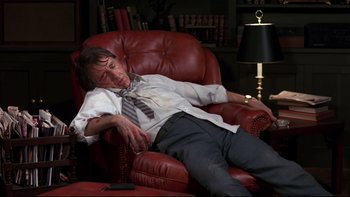 Movie still from “Creepshow” (1982), directed by George A. Romero – A man is sleeping on a chair in a living room; Medium shot, High angle