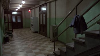 Movie still from “Creepshow” (1982), directed by George A. Romero – A hallway with a tiled floor and a green wall; Wide shot, High angle