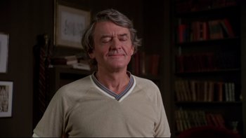 Movie still from “Creepshow” (1982), directed by George A. Romero – An older man with grey hair is standing in front of a book shelf; Close Up shot, Low angle