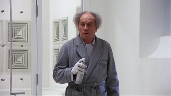 Movie still from “Creepshow” (1982), directed by George A. Romero – An old man in a gray robe holding a spray bottle; Medium shot, Low angle