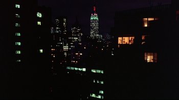 Movie still from “Creepshow” (1982), directed by George A. Romero – A view of a city skyline at night with lights on buildings; Extreme Wide shot, High angle