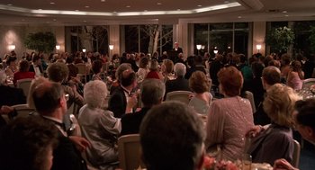 Movie still from “Crimes and Misdemeanors” (1989), directed by Woody Allen – A group of people sitting at tables in a room; Wide shot, High angle