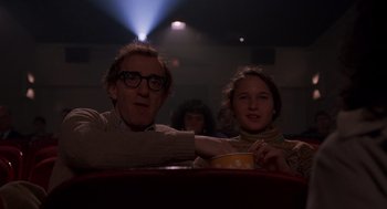 Movie still from “Crimes and Misdemeanors” (1989), directed by Woody Allen – A man and a woman sitting in a movie theater; Medium shot, Low angle