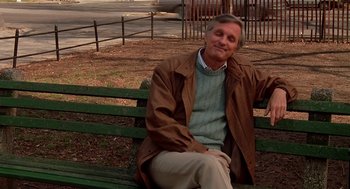 Movie still from “Crimes and Misdemeanors” (1989), directed by Woody Allen – An older man sitting on a park bench; Medium shot, Over the shoulder angle