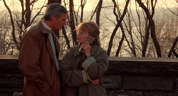 Movie still from “Crimes and Misdemeanors” (1989), directed by Woody Allen – A man and a woman standing next to each other talking; Medium shot, Over the shoulder angle