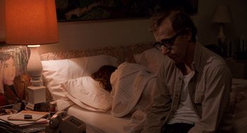 Movie still from “Crimes and Misdemeanors” (1989), directed by Woody Allen – A man sitting on a bed next to a woman; Medium shot, Over the shoulder angle