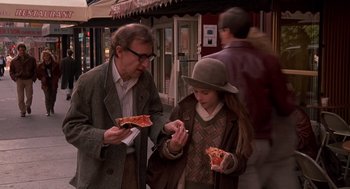 Movie still from “Crimes and Misdemeanors” (1989), directed by Woody Allen – A man and a woman eating pizza outside; Medium shot, Over the shoulder angle