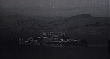 Movie still from “Crimes and Misdemeanors” (1989), directed by Woody Allen – A black - and - white photo of a building on top of a hill; Extreme Wide shot, High angle