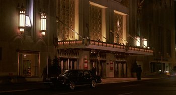 Movie still from “Crimes and Misdemeanors” (1989), directed by Woody Allen – A car parked in front of a building at night; Extreme Wide shot, Low angle