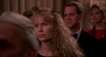 Movie still from “Crimes and Misdemeanors” (1989), directed by Woody Allen – A person with long curly hair; Close Up shot, Over the shoulder angle