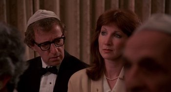 Movie still from “Crimes and Misdemeanors” (1989), directed by Woody Allen – A man and a woman wearing a suit and tie; Close Up shot, Over the shoulder angle