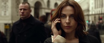 Movie still from “Criminal” (2016), directed by Ariel Vromen – A woman is talking on a cell phone; Close Up shot, Low angle