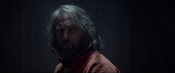 Movie still from “Criminal” (2016), directed by Ariel Vromen – A man with long grey hair and a beard; Close Up shot, Over the shoulder angle