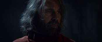 Movie still from “Criminal” (2016), directed by Ariel Vromen – A person with long hair and a beard; Close Up shot, Over the shoulder angle