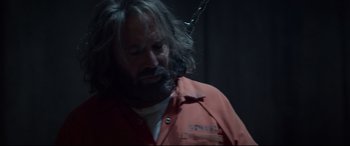 Movie still from “Criminal” (2016), directed by Ariel Vromen – A man with a beard is wearing an orange shirt; Medium shot, Over the shoulder angle