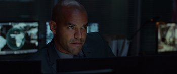 Movie still from “Criminal” (2016), directed by Ariel Vromen – A man in a suit looking at a computer screen; Close Up shot, Over the shoulder angle