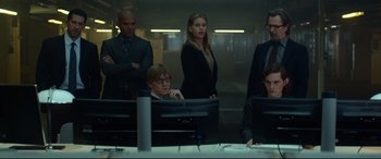 Movie still from “Criminal” (2016), directed by Ariel Vromen – A group of people standing in front of computer monitors; Medium shot, Low angle