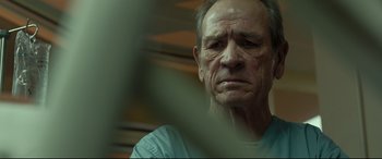 Movie still from “Criminal” (2016), directed by Ariel Vromen – An older man with a sad look on his face; Close Up shot, Low angle