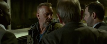 Movie still from “Criminal” (2016), directed by Ariel Vromen – A man with a goatee talking to another man; Close Up shot, Over the shoulder angle