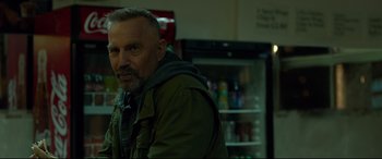 Movie still from “Criminal” (2016), directed by Ariel Vromen – A person standing in a room near a refrigerator; Close Up shot, Over the shoulder angle