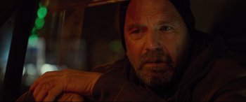 Movie still from “Criminal” (2016), directed by Ariel Vromen – A person wearing a hoodie; Close Up shot, Over the shoulder angle