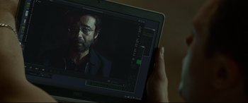 Movie still from “Criminal” (2016), directed by Ariel Vromen – A person holding a laptop with a picture of a man on the screen; Close Up shot, Over the shoulder angle