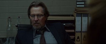 Movie still from “Criminal” (2016), directed by Ariel Vromen – A person wearing a suit and tie; Close Up shot, Low angle